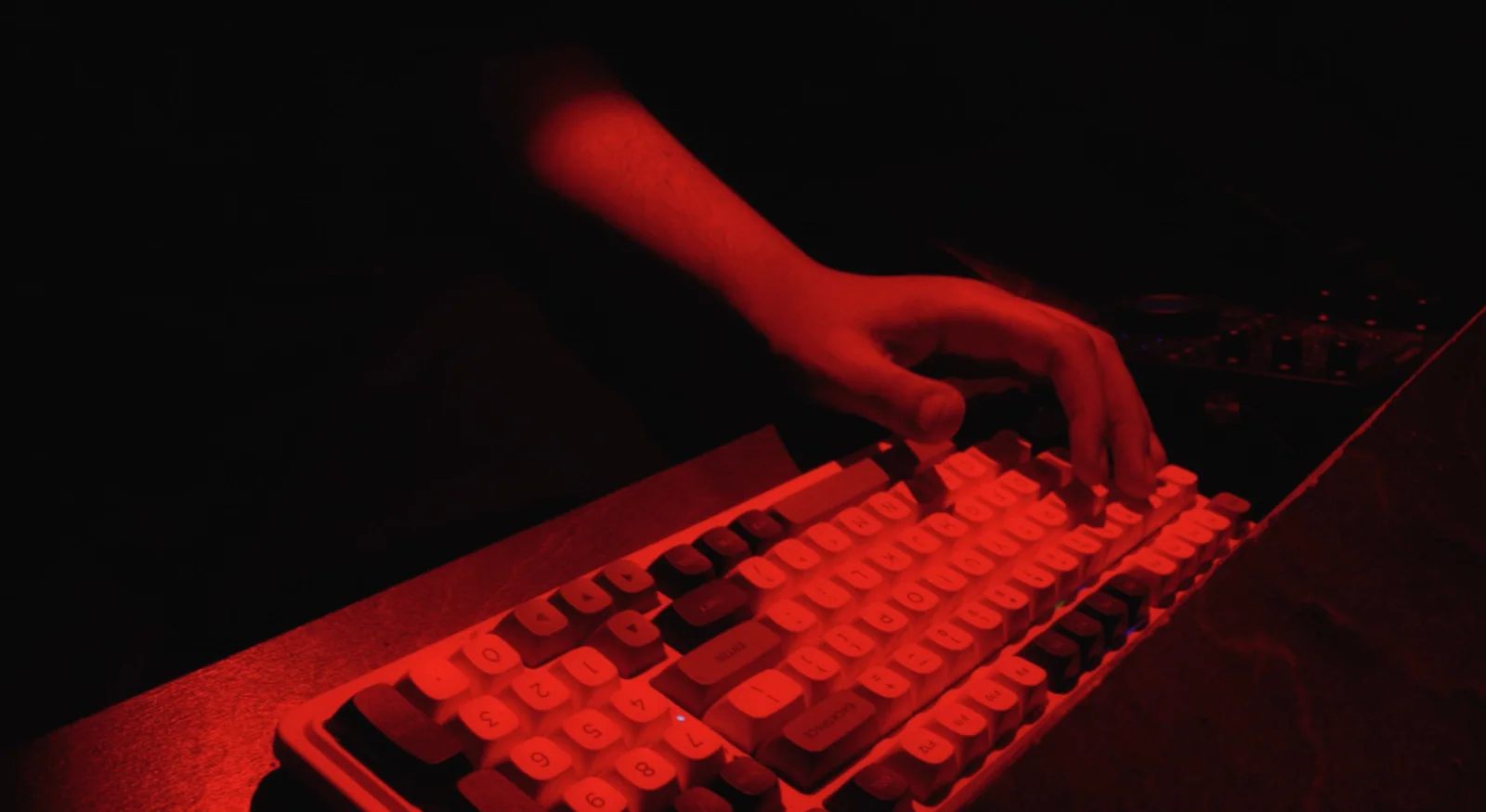 Hands on the keys in red light