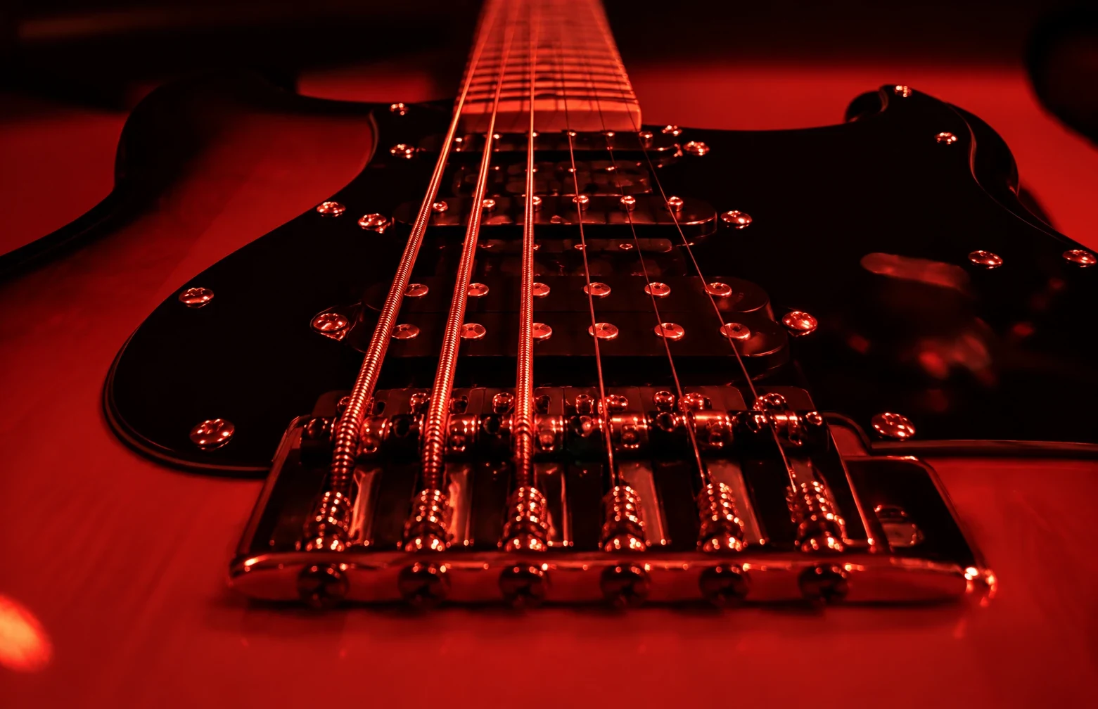Guitar strings and bridge under red light